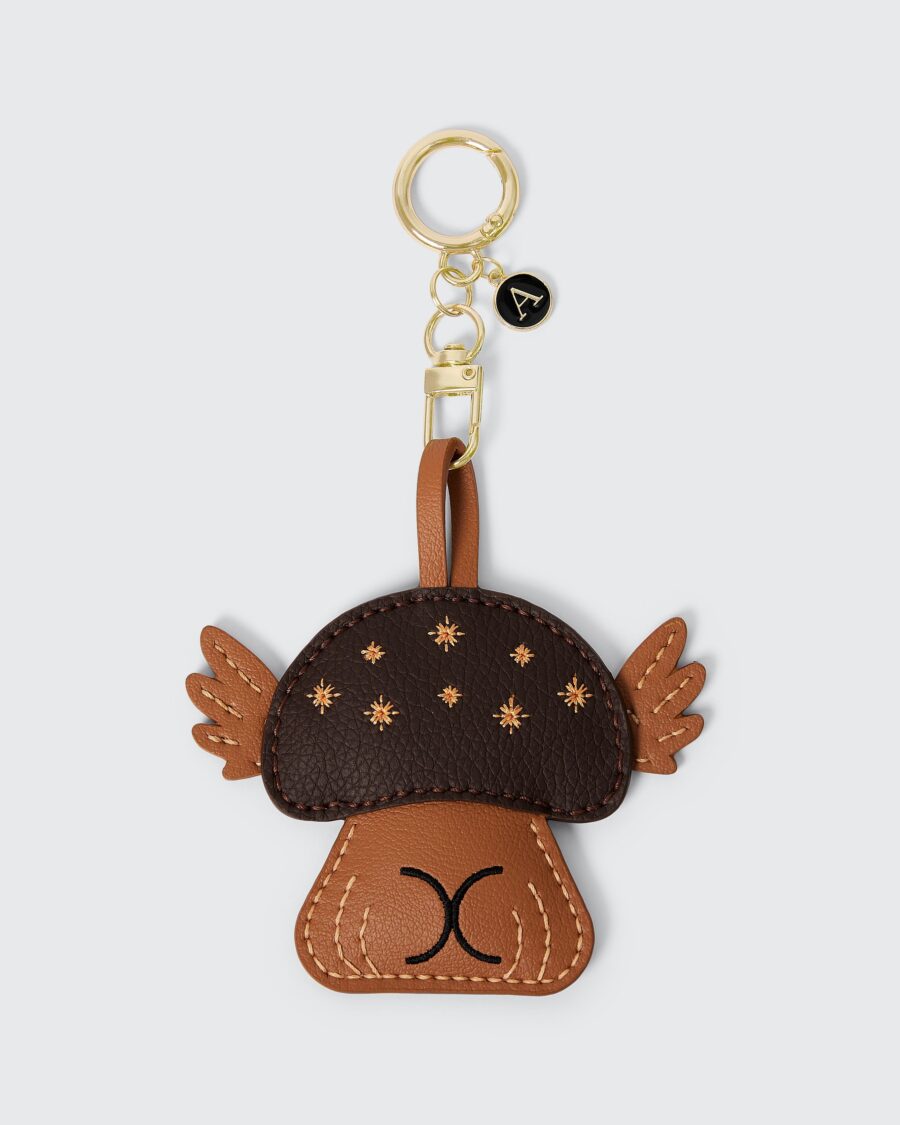 Handmade vegan leather keychain featuring a smiling mushroom design